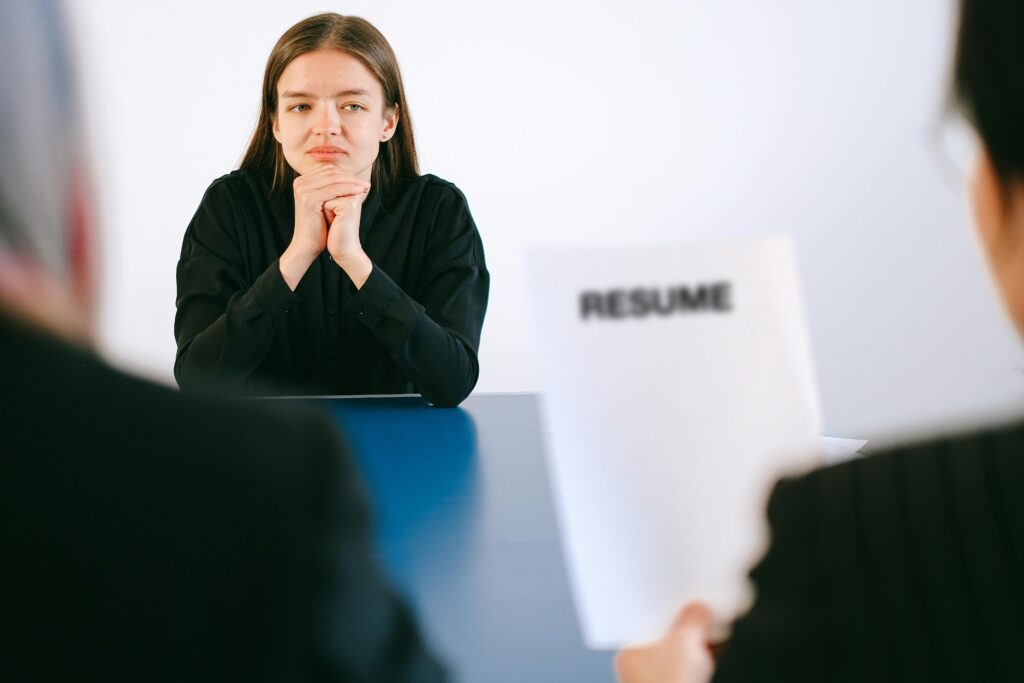 Job candidate looking on as an interviewer reviews their resume.